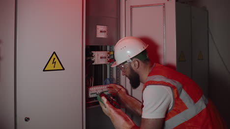 electrician working on electrical panel at night