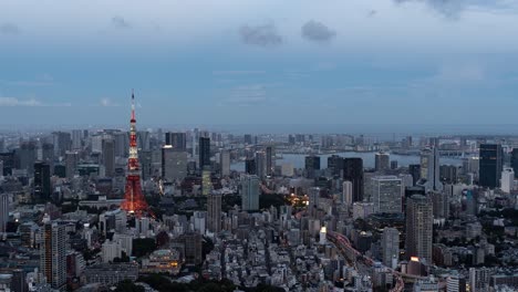 beautiful 4k timelapse over tokyo cityscape at dusk illumination lighting up tokyo tower - zoom out