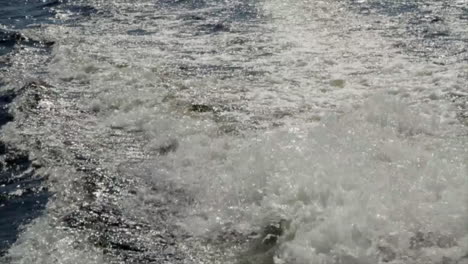 this is a shot of water churning from behind a boat as it travels around a lake