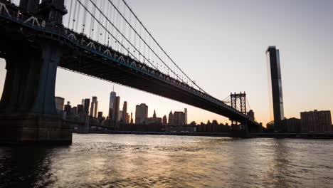 Panning-timlapse-over-NYC-manhattan,-Manhattan-bridge,-broklyn-bridge-and-east-river-at-sunset-from-the-viewpoint-of-DUMBO-Brooklyn