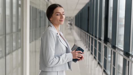 Retrato-De-Primer-Plano-De-Una-Mujer-Hermosa-En-Un-Traje-Azul-Con-Un-Cuaderno-Y-Un-Teléfono-Inteligente