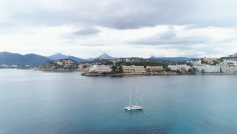 toma aérea de un barco en el mar con la costa al fondo, 4k uhd