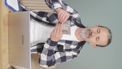 vertical video of old man distributing banknotes and tossing them into the air.