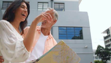 una pareja sonriente chequeando el mapa.
