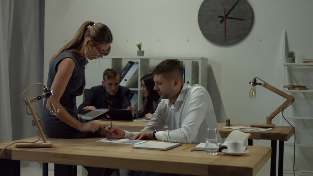 Dos colegas de negocios discutiendo un gráfico en la oficina.