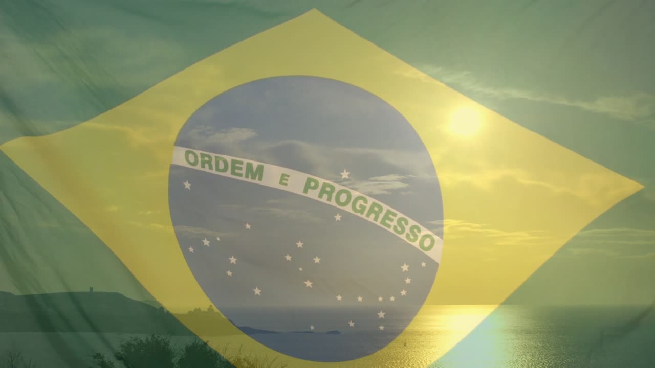 海上にブラジル国旗が透けて見え、昇る太陽が波紋とフレアを生み出し、岸辺が輝く。
