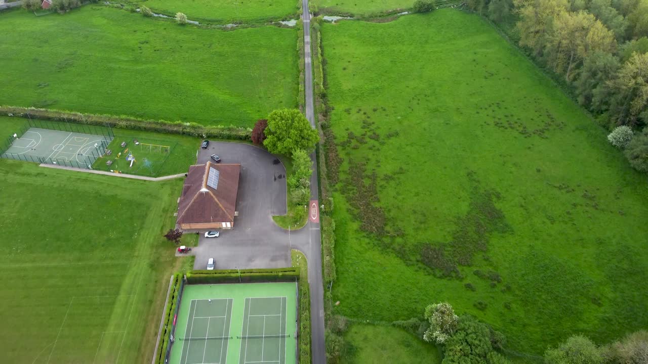 Aerial video flying over a tennis court and local sport centre
