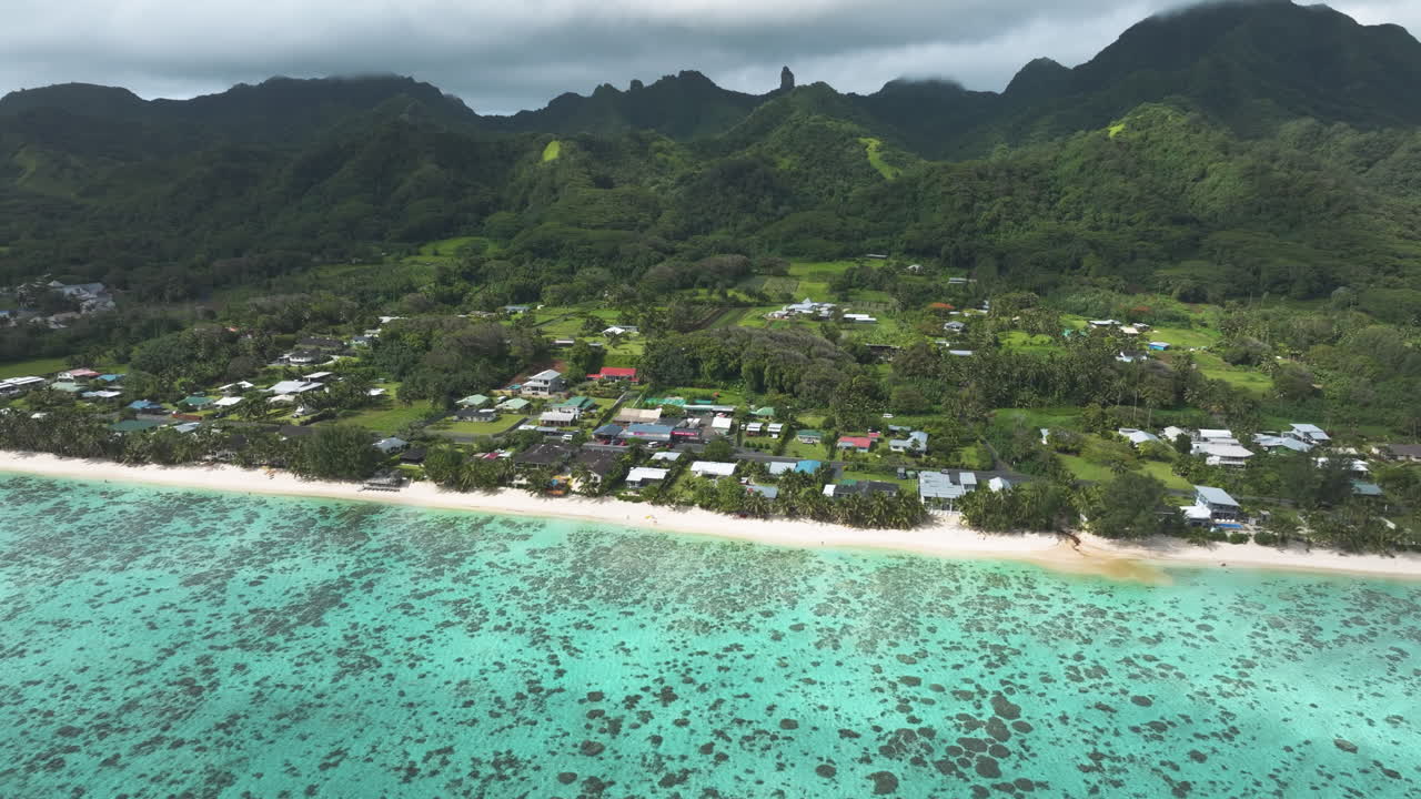 Golden sunlight illuminates mountain peaks in Rarotonga Cook Islands above coastal homes