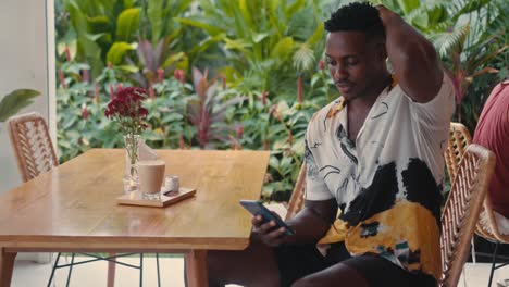hombre usando un teléfono inteligente en un café