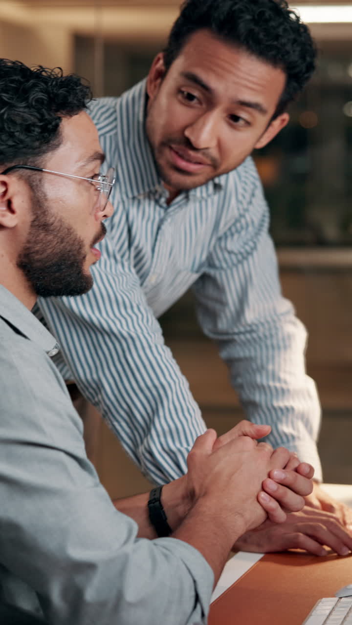 Two Men Collaborating and Discussing Work in a Modern Office