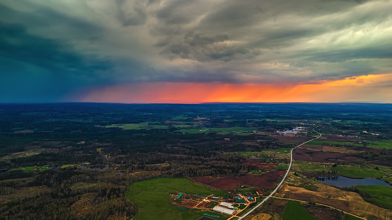 Aerial time-lapse of dramatic sunset, rain clouds moving over the countryside