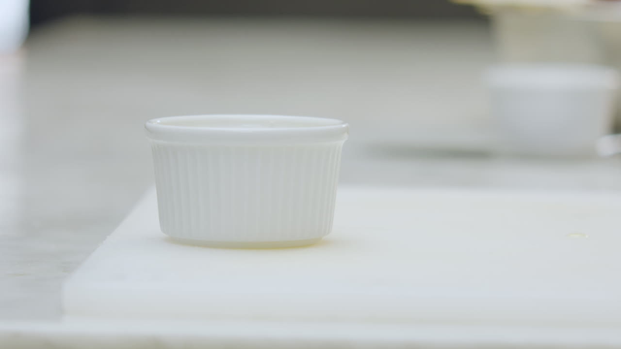 Close-up of a chef placing a ceramic mold on a chopping board
