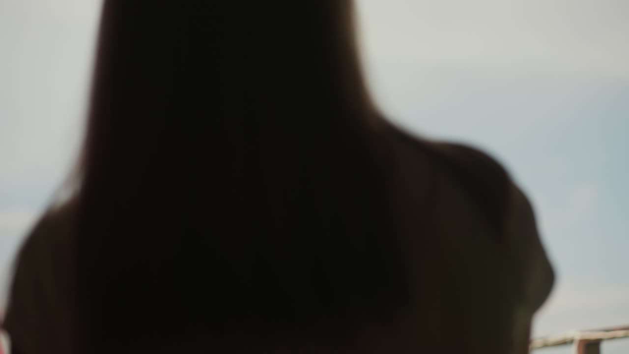 white man rooftop smiling with partner, candid profile shots against blue sky, backlit warmth, casual shirt and shaved head, tender glances, relaxed conversation and intimate connection during daytime