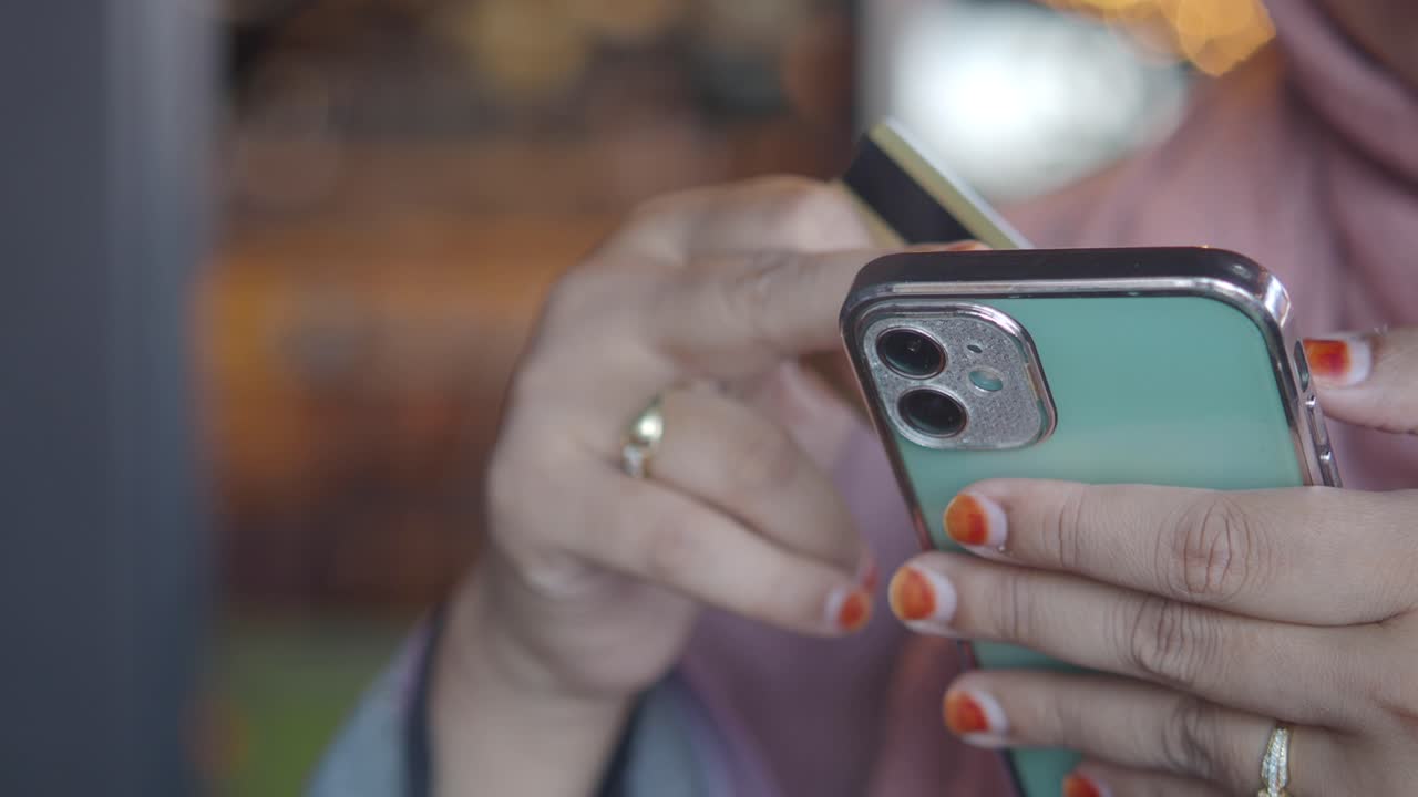 A person's hand holding a credit card