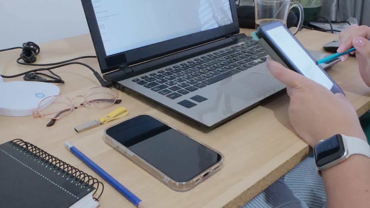 Hands using a tablet for digital documents, alongside a laptop, illustrating a modern paperless