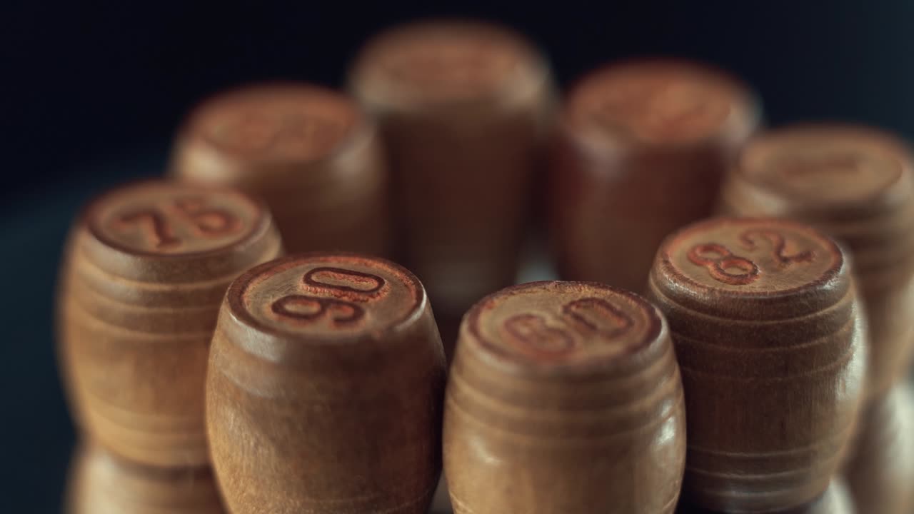 Macro video of wooden Bingo barrels, casino gambling game, digits on top, 360 rotating numbers, 120 fps, slow motion
