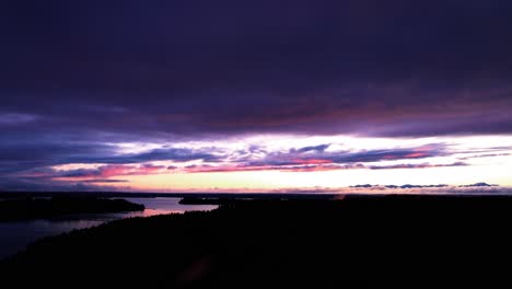 Deep-orange-red-and-purple-colors,-sunset-reflection,-slow-aerial-track