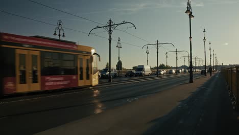 busy bridge with cars, vans, and a tram moving during sunset, budapest, hungary