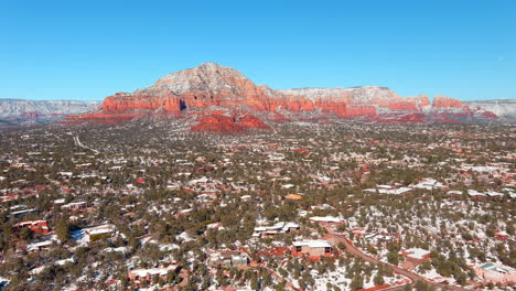 sedona, arizona and a distant mountain peak, capitol butte, after light snow - aerial parallax