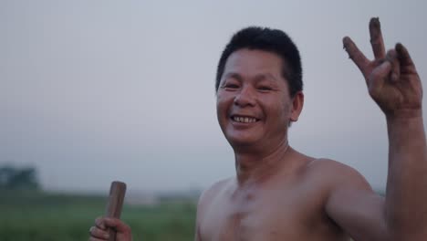 smiling farmer showing peace sign