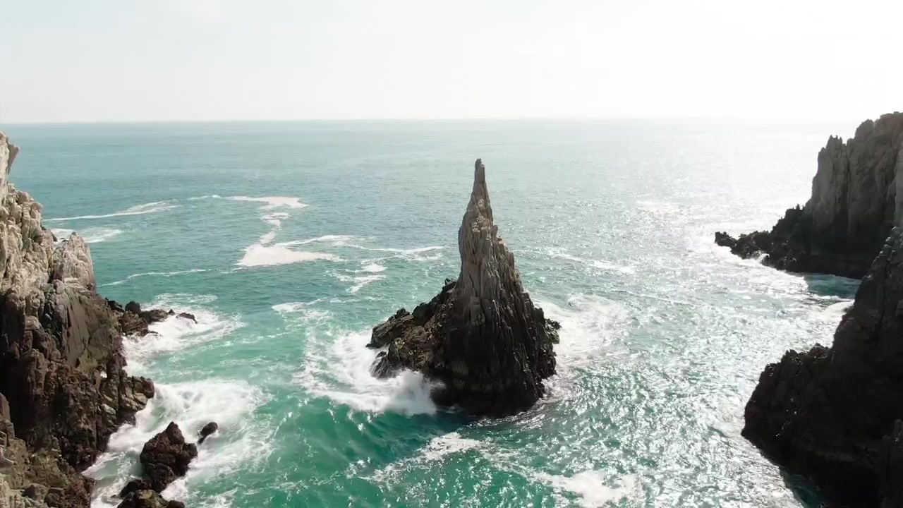 Tomada aérea de revelação do monólito marinho Dedo de Dios emoldurado por falésias e águas turquesas do Pacífico em Michoacán, México.