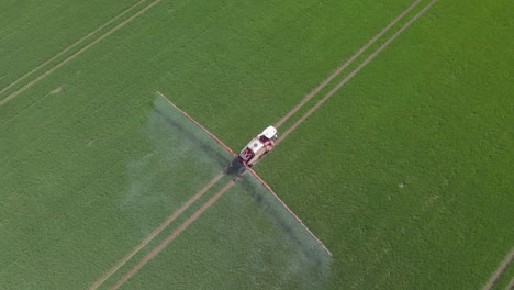 vista aérea de un granjero rociando cultivos en un campo en aberdeenshire en un día soleado, escocia
