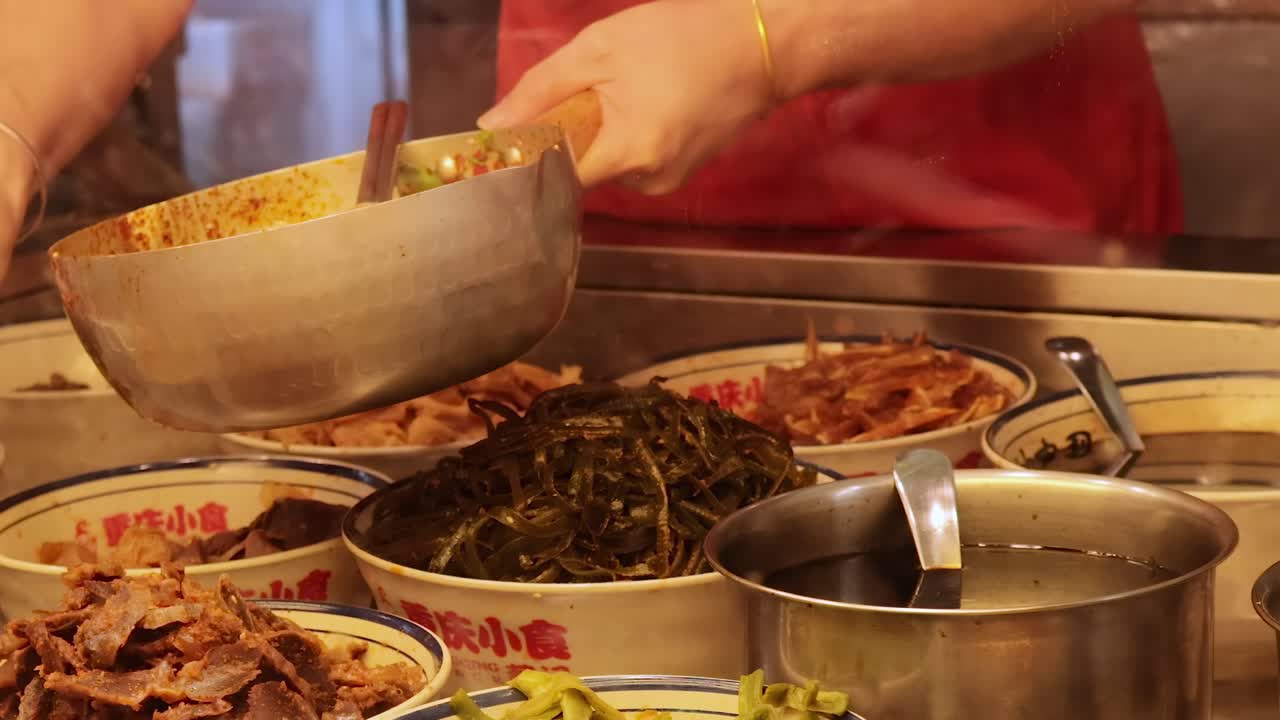 A vendor skillfully serves various dishes from a vibrant food stall display.