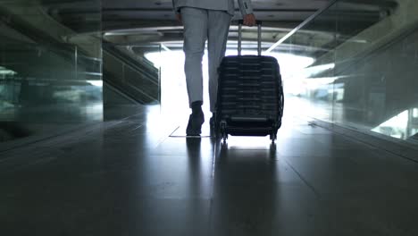 low section of businessman with suitcase in airport