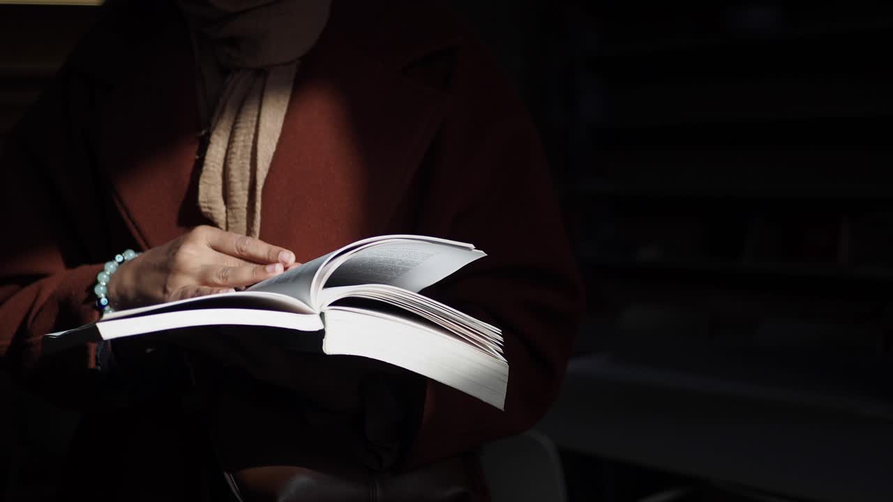 mujer leyendo un libro en una biblioteca