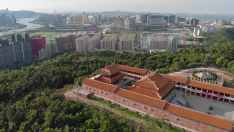 rotating aerial view of a-ma temple with macau cityscape in background