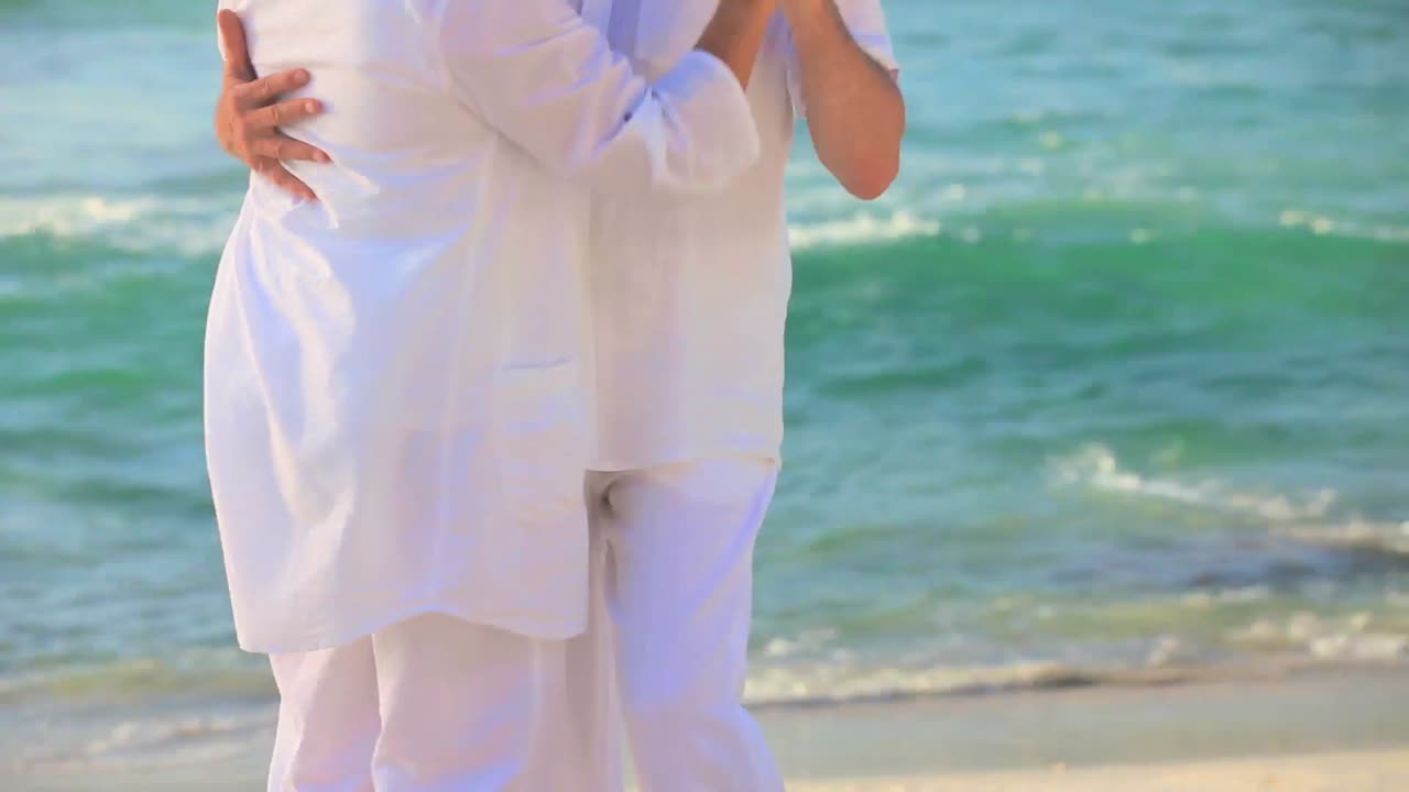 노인 부부가 해변에서 춤을 추고 있다