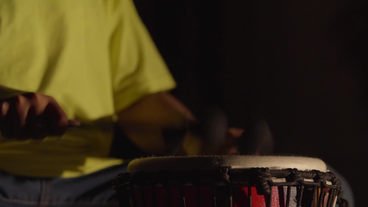 Child plays drums with lights flickering on and off.