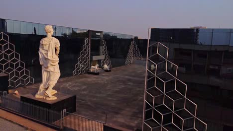 jib up of a beautiful statue overlooking the courtyard in front of a modern office building in abuja, nigeria