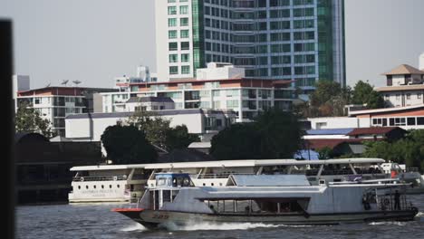 Experimente-Bangkok-Desde-El-Agua-Con-Un-Vibrante-Ferry-Naranja-Que-Navega-Por-El-Río-Chao-Phraya,-Una-Atracción-Imperdible