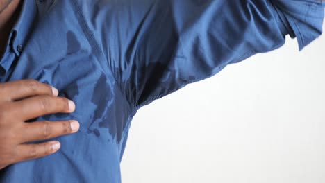 hombre con manchas de sudor en su camisa
