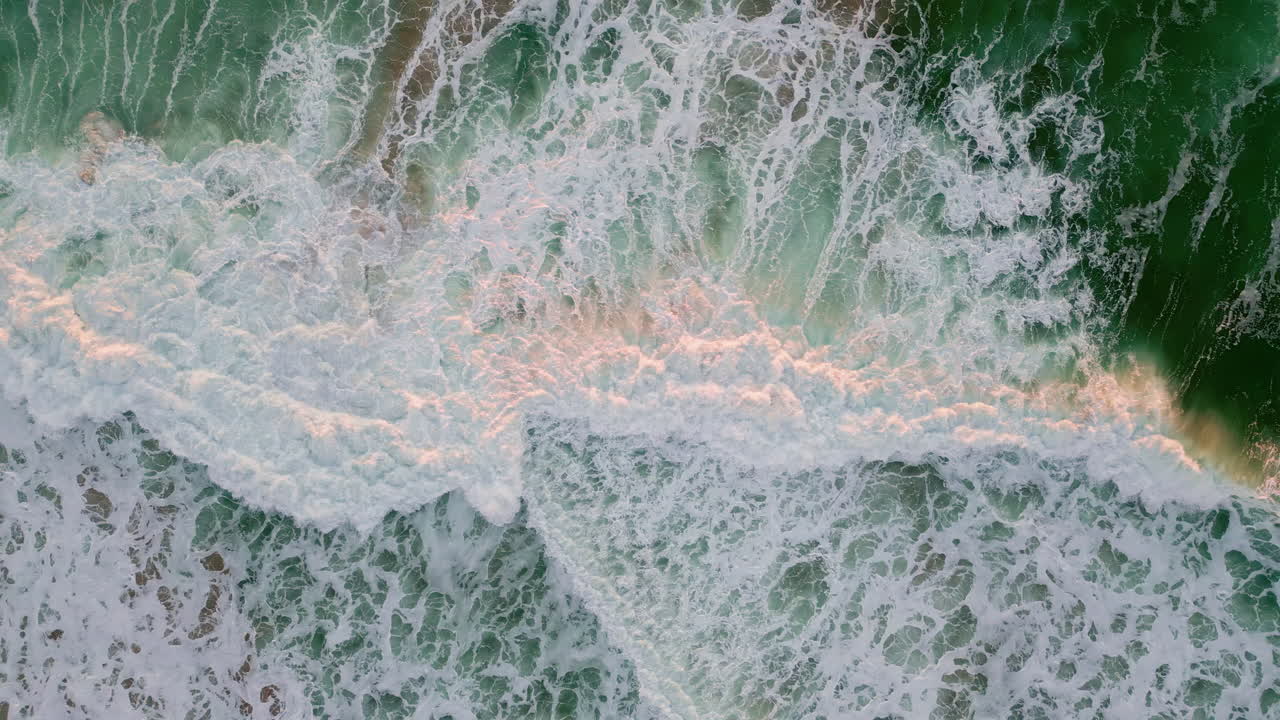 Foamy waves splashing shore top view. Stormy ocean washing beach