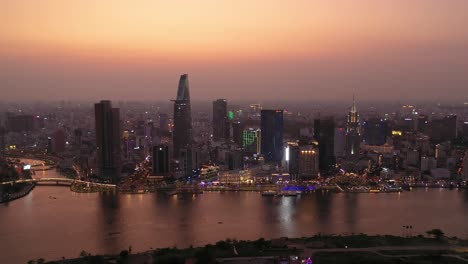 ciudad de ho chi minh, horizonte icónico de vietnam y panorama aéreo frente al río saigon en una noche ocupada con todos los edificios clave iluminados contra un hermoso cielo de colores