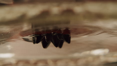 Macro-shot-of-ferrofluid---magnetic-oil---hanging-upside-down-at-a-petri-dish