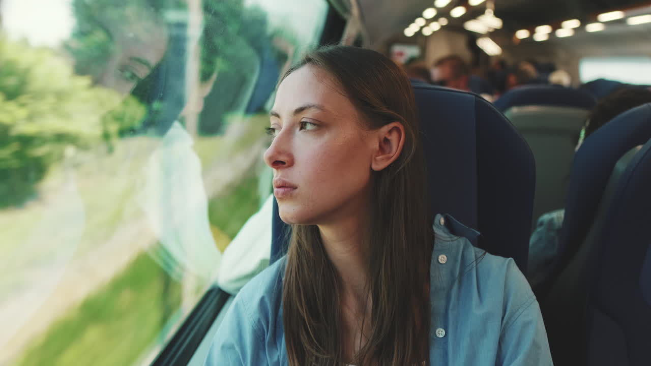 Young Woman Looking Out Train Window During Journey