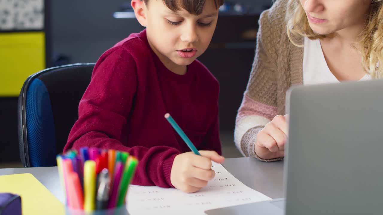 video de mano del hijo haciendo la tarea de matemáticas con la madre