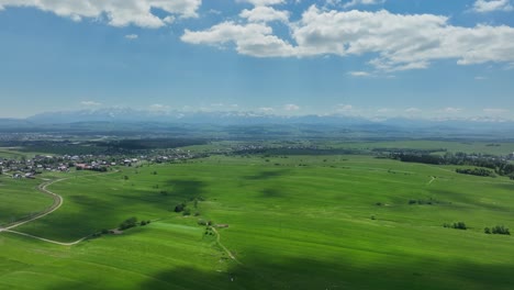 sunlit clouds above verdant lush meadow and tatra mountains scenic aerial