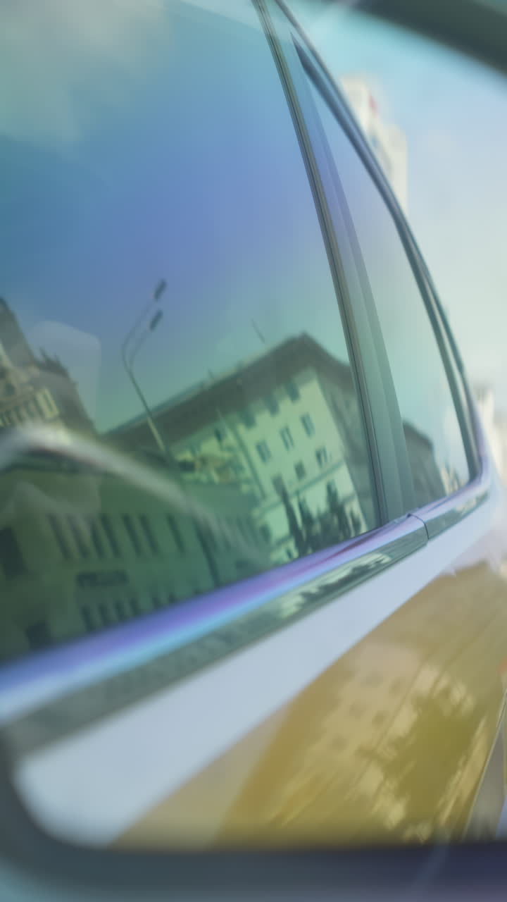 Riflesso del paesaggio urbano nel finestrino dell'auto