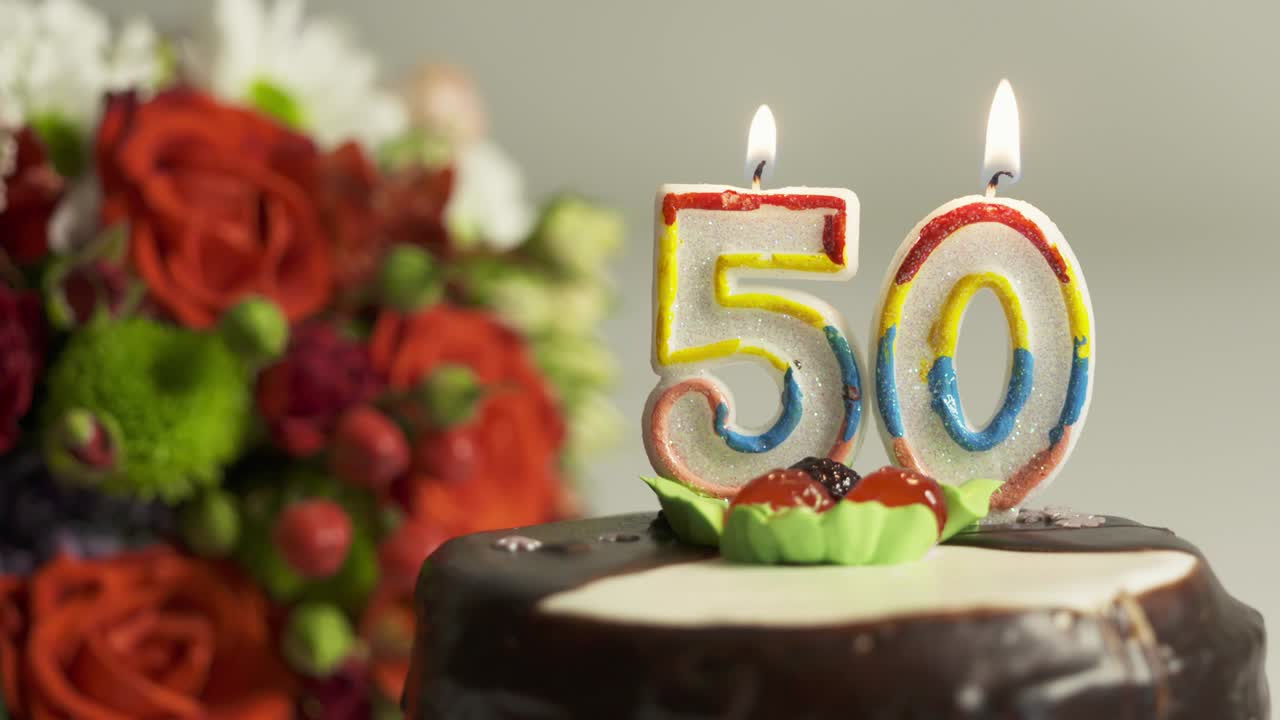 dolly: arreglo de flores y pastel de cumpleaños con vela encendida número 50