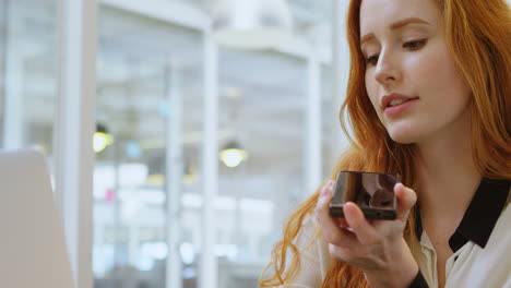 female executive talking on mobile phone while working on laptop 4k