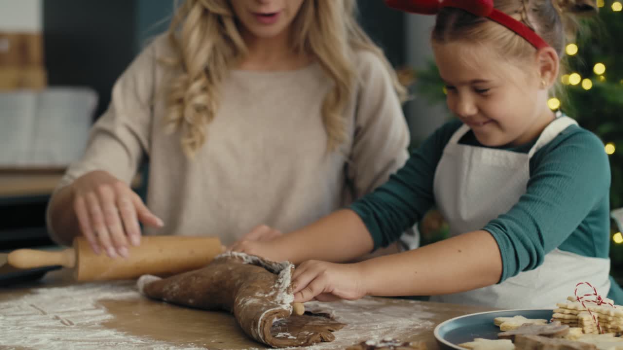 Caucasian woman with daughter making cookies in Christmas time in the kitchen.