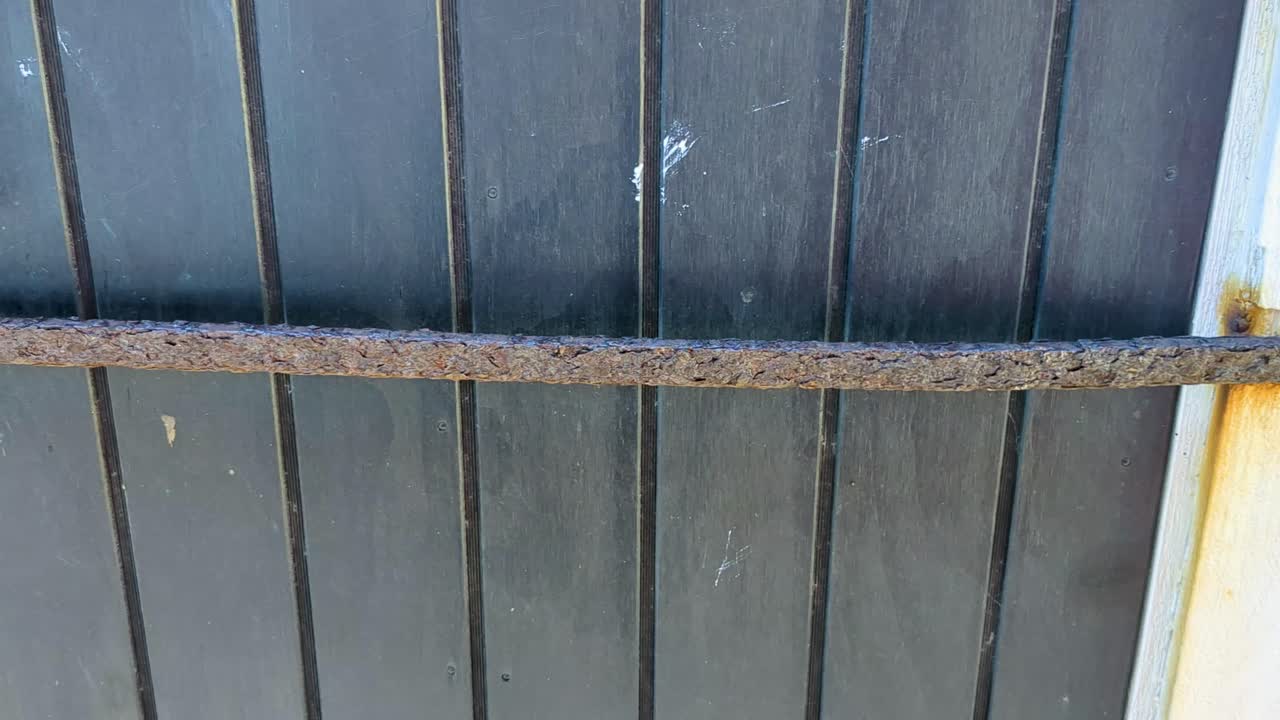 detalle de un primer plano de 4k 60fps de una vieja puerta desgastada con cerradura y barra de metal de una cabaña, pesca sahed - tiro de camión