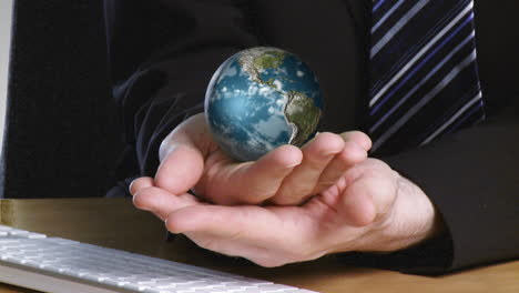 businessman with a rotary terrestrial globe in his hand