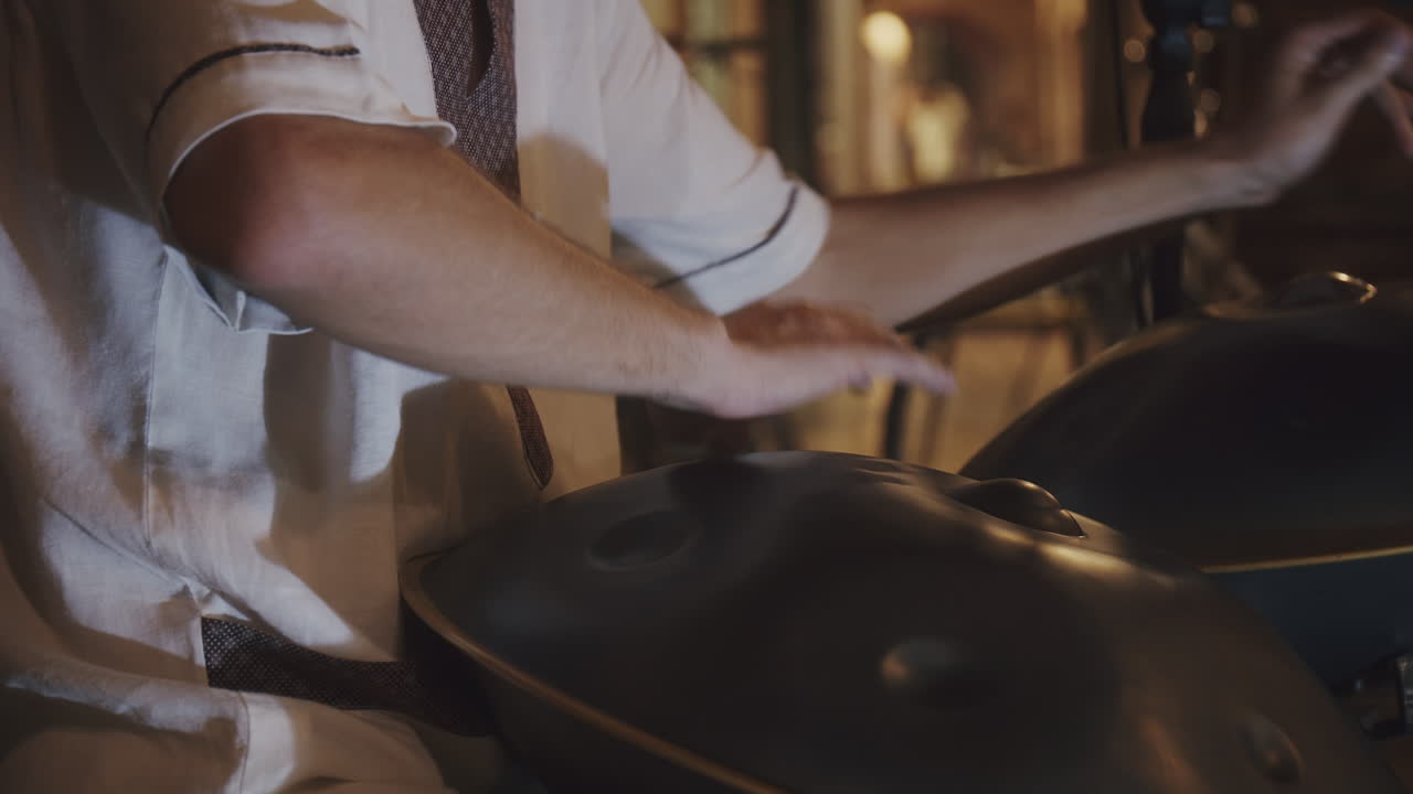 músico callejero experto en túnica blanca toca la batería en la calle durante el festival de verano