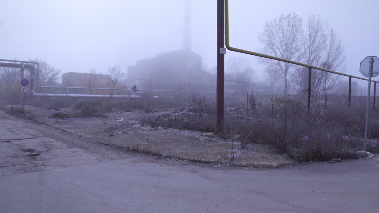 Una vecchia zona industriale abbandonata, spaventosa, inquietante, da film horror, in decadenza con edifici in rovina, rifiuti, accanto a una stazione ferroviaria dell'era comunista nei Balcani in Bulgaria, Europa Orientale.