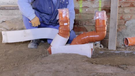 builder fixing sewage pipe with masking tape stock video